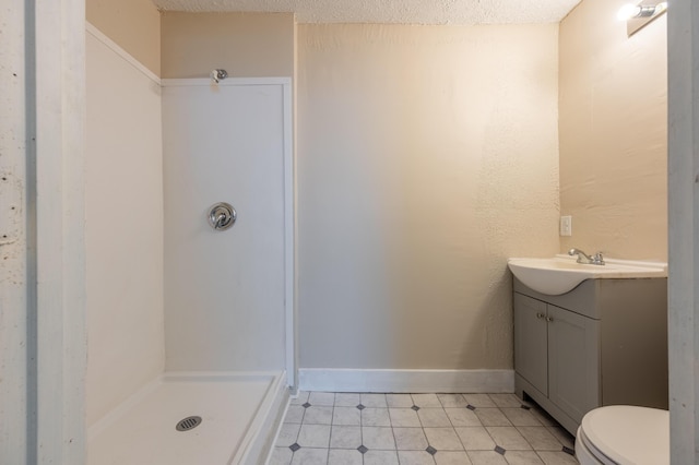 bathroom featuring toilet, a shower, a textured ceiling, and vanity