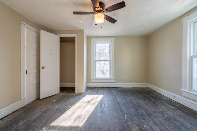 unfurnished bedroom featuring dark wood-type flooring, ceiling fan, and a textured ceiling