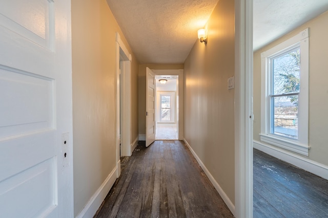 hall with dark hardwood / wood-style flooring and a textured ceiling