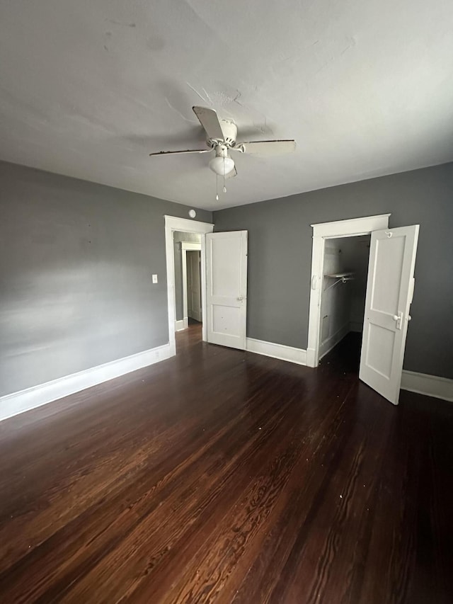 unfurnished bedroom featuring ceiling fan, dark hardwood / wood-style floors, and a closet