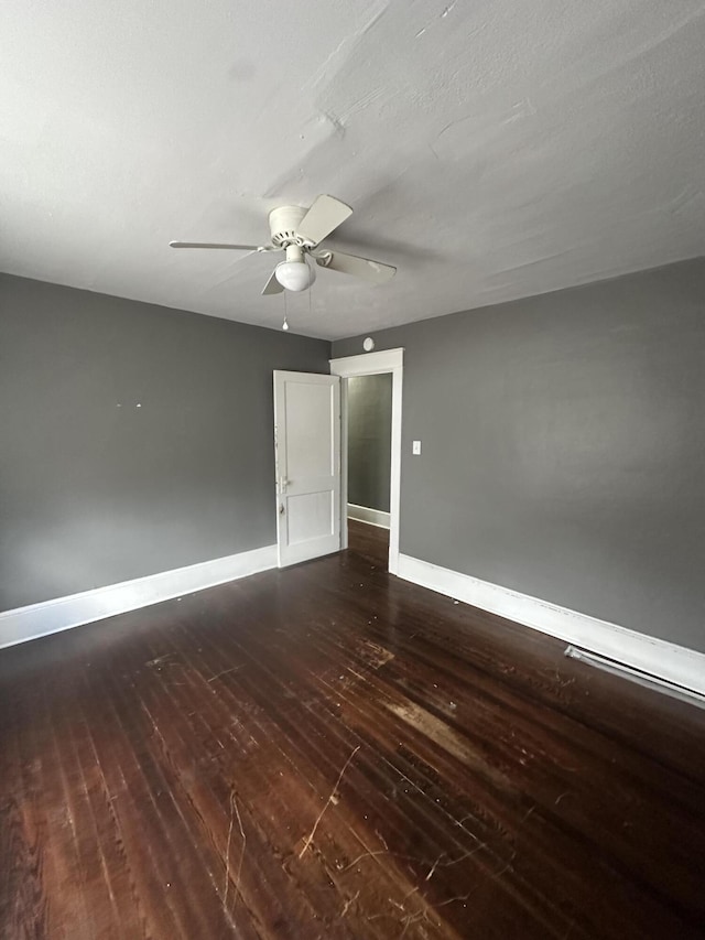 empty room featuring ceiling fan and dark wood-type flooring