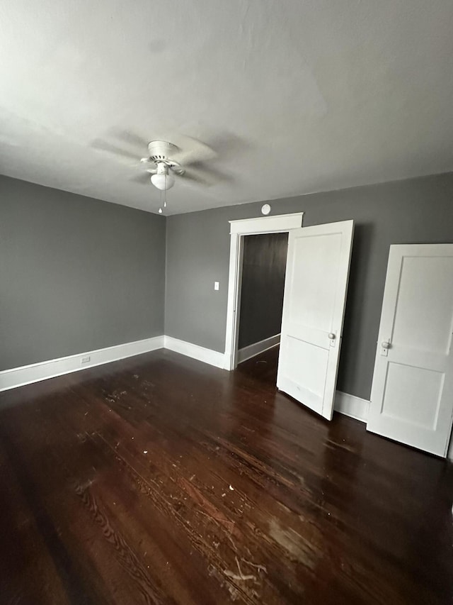 unfurnished bedroom featuring dark hardwood / wood-style floors and ceiling fan