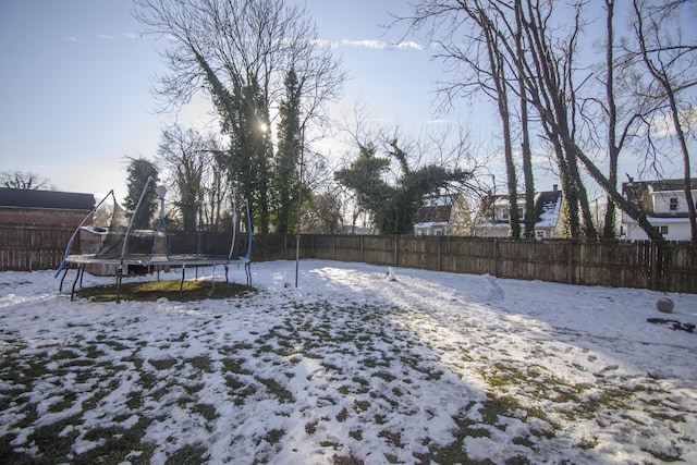 yard covered in snow featuring a trampoline