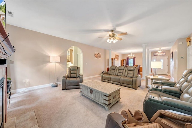 carpeted living room featuring ceiling fan with notable chandelier and a fireplace