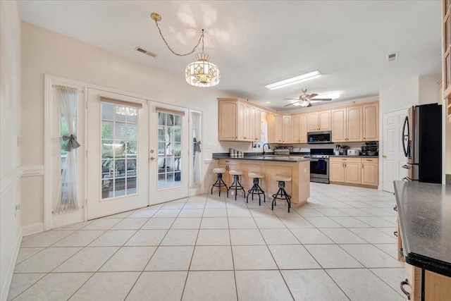 kitchen featuring kitchen peninsula, stainless steel appliances, french doors, light tile patterned floors, and a breakfast bar area