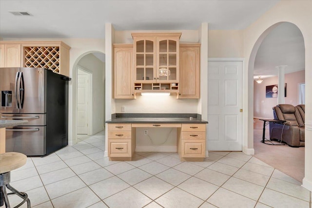 kitchen featuring stainless steel fridge, light carpet, and light brown cabinets