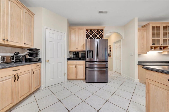 kitchen featuring light brown cabinetry, light tile patterned floors, and stainless steel fridge with ice dispenser