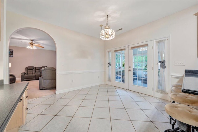 interior space featuring ceiling fan with notable chandelier and french doors