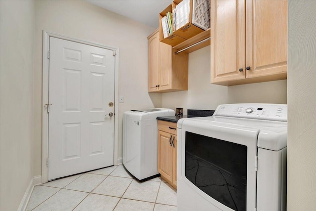 washroom with cabinets, light tile patterned flooring, and washer and clothes dryer