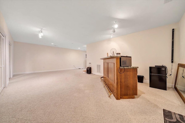 interior space with light colored carpet and track lighting