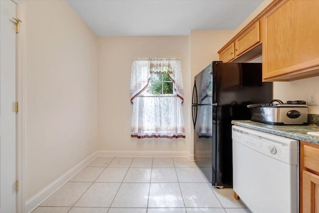 kitchen with light stone counters, light tile patterned flooring, and dishwasher