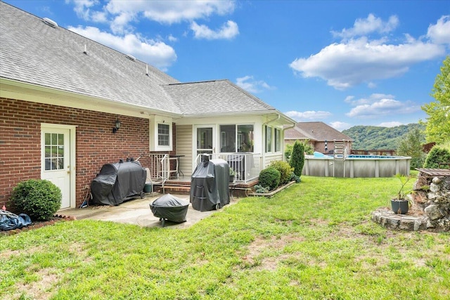 back of house with a patio area, a lawn, and a fire pit