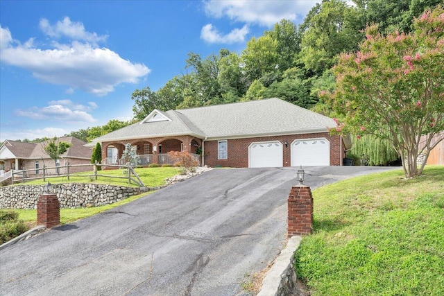 ranch-style house featuring a front yard and a garage