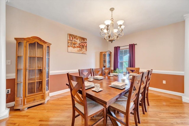 dining area with an inviting chandelier and light hardwood / wood-style floors