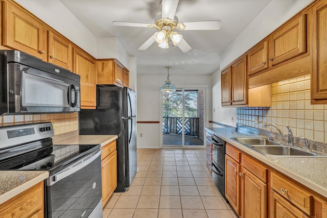 kitchen featuring backsplash, black appliances, sink, light tile patterned floors, and decorative light fixtures