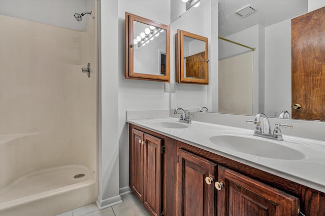 bathroom with tile patterned flooring, vanity, and walk in shower