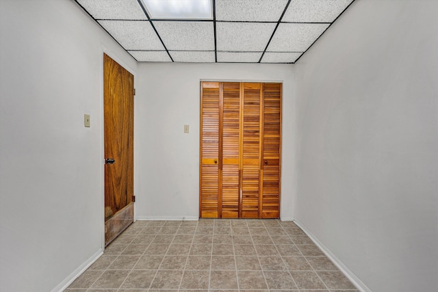 unfurnished bedroom with a paneled ceiling and a closet