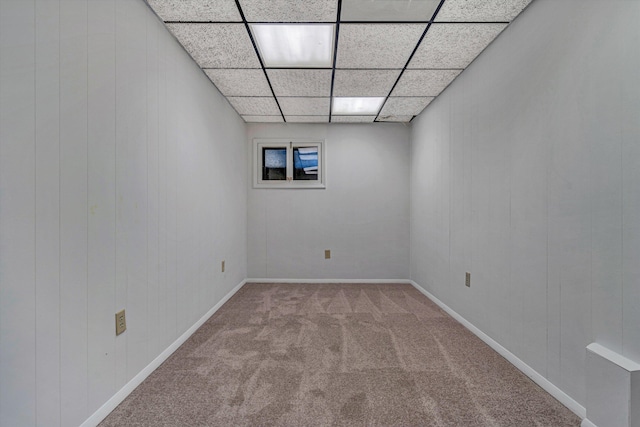 carpeted spare room featuring a drop ceiling