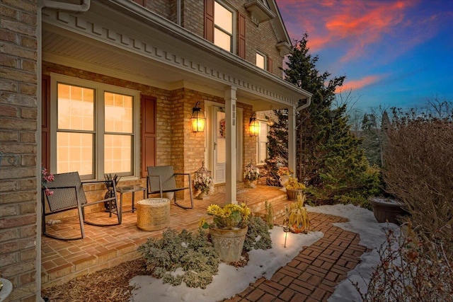 patio terrace at dusk featuring a porch