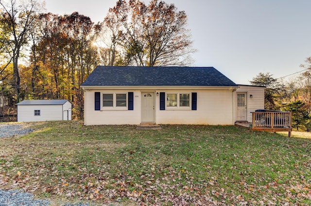 view of front of home featuring a storage unit, a yard, and a wooden deck