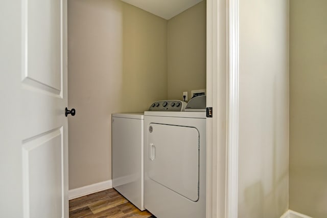 clothes washing area featuring washing machine and dryer and hardwood / wood-style flooring