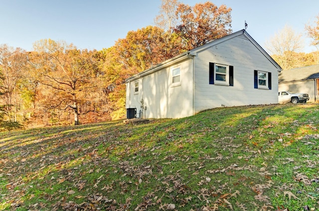 view of side of property with cooling unit and a lawn