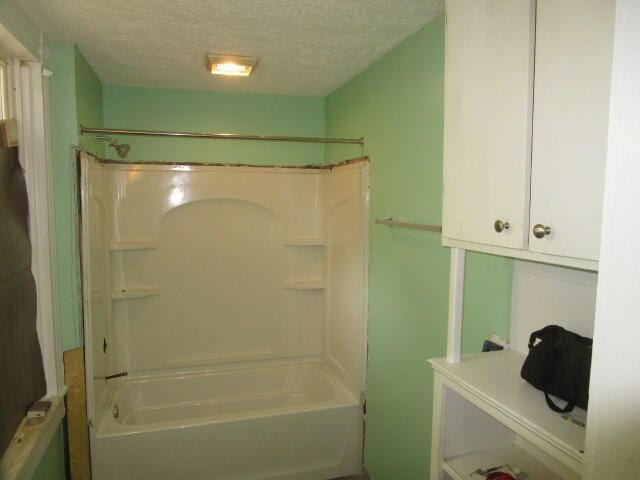 bathroom featuring a textured ceiling and shower / washtub combination