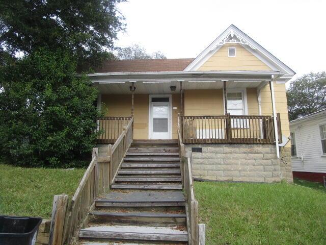 view of front of home featuring covered porch and a front yard