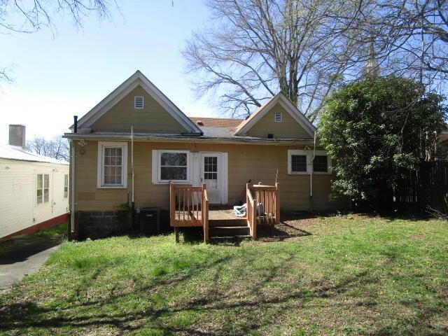 rear view of house featuring a yard, a deck, and central AC unit