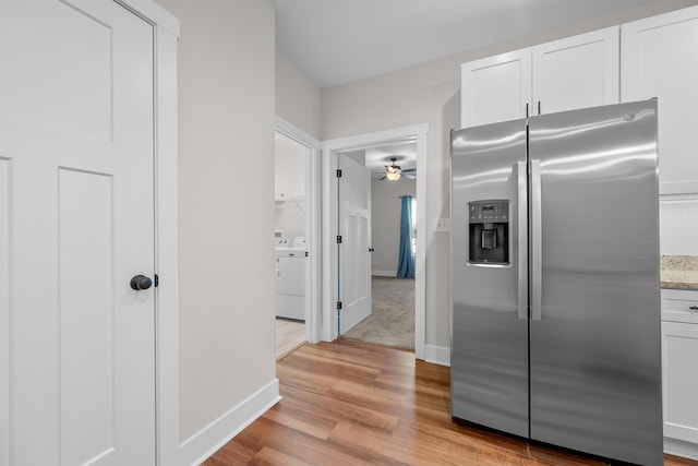 kitchen with ceiling fan, stainless steel refrigerator with ice dispenser, light hardwood / wood-style floors, washer / dryer, and white cabinets