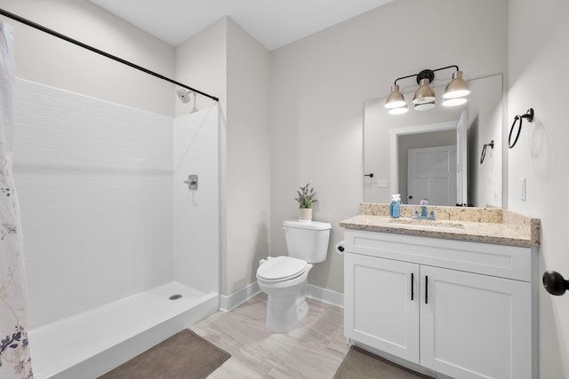 bathroom with toilet, vanity, and walk in shower