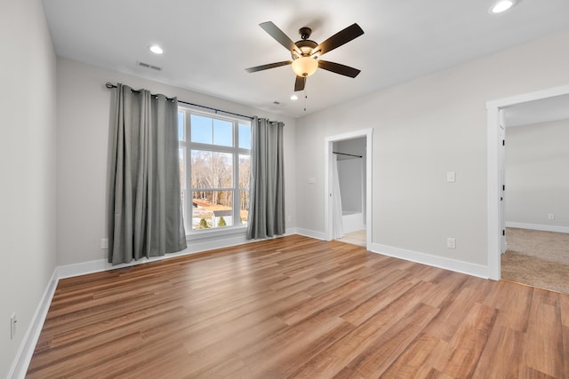 unfurnished bedroom featuring ceiling fan, light wood-type flooring, and connected bathroom