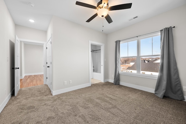 unfurnished bedroom featuring carpet, ceiling fan, and ensuite bath