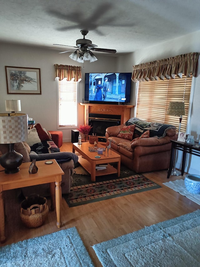 living room featuring wood-type flooring and ceiling fan