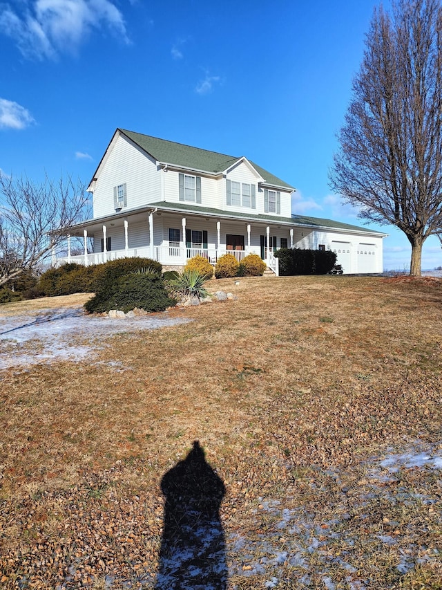 country-style home with covered porch, a front lawn, and a garage