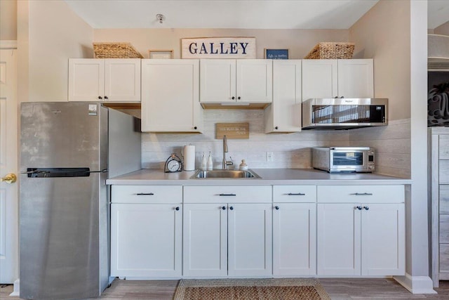 kitchen with white cabinets, stainless steel appliances, and tasteful backsplash