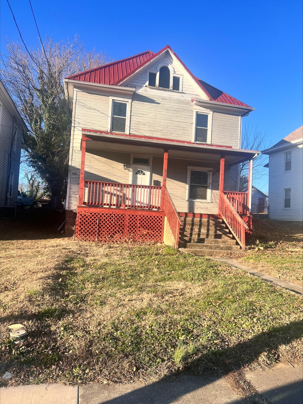 view of front facade featuring covered porch and a front lawn