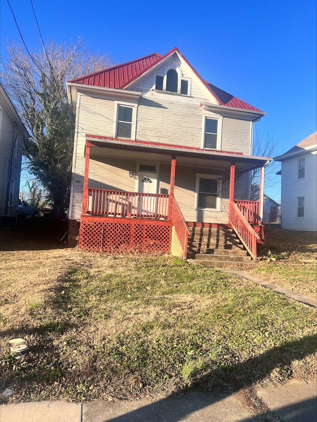 view of front facade featuring covered porch and a front lawn