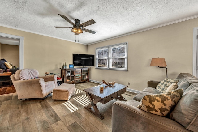 living room featuring wood-type flooring, a textured ceiling, ceiling fan, and crown molding