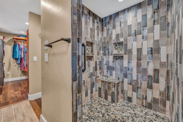 bathroom featuring tiled shower and wood-type flooring