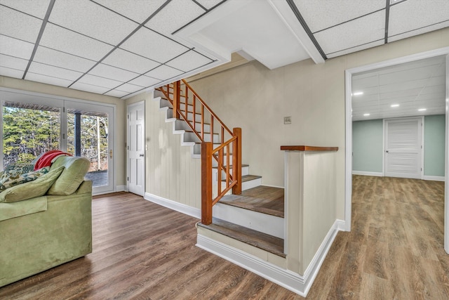 stairway featuring hardwood / wood-style floors and a paneled ceiling