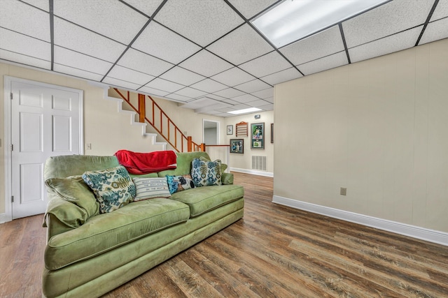 living room featuring a drop ceiling and dark hardwood / wood-style floors