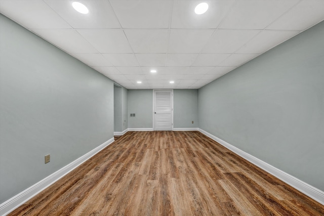 empty room with hardwood / wood-style flooring and a paneled ceiling