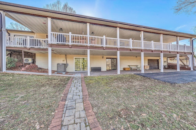 back of house with central AC unit, a patio, and a lawn