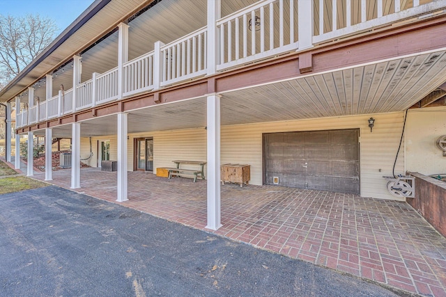 view of patio / terrace with a garage, a balcony, and central AC