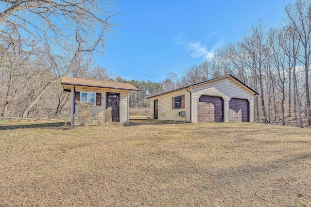 view of front of house with a garage, an outdoor structure, and a front yard