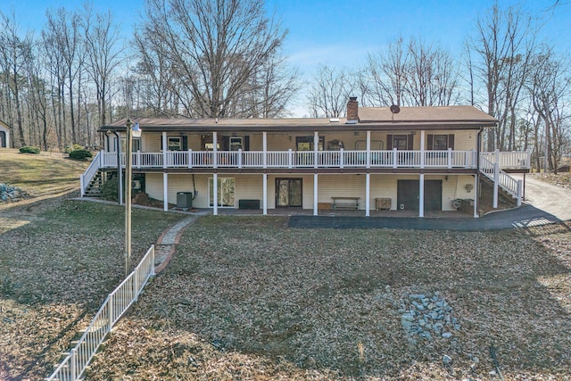 back of house featuring cooling unit, a yard, a deck, and a patio