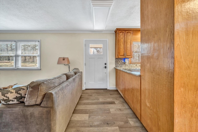 kitchen featuring decorative backsplash, light hardwood / wood-style floors, and a textured ceiling