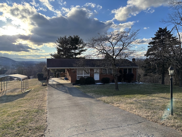 view of front of house with a carport, a mountain view, and a front yard