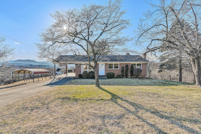 single story home featuring a carport, a mountain view, and a front yard